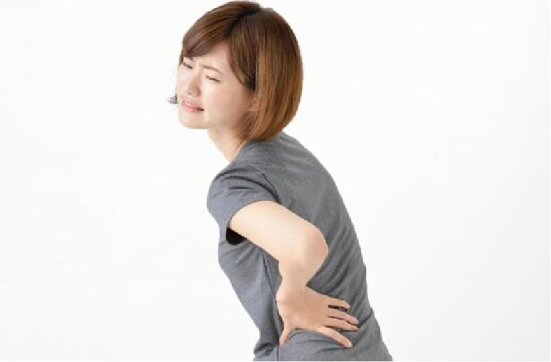 腰を押さえて痛がる女性